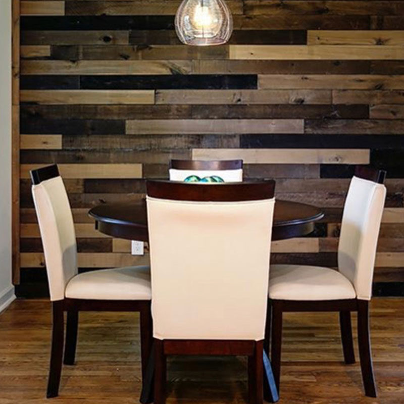 Modern dining room with a wooden accent wall and white chairs.