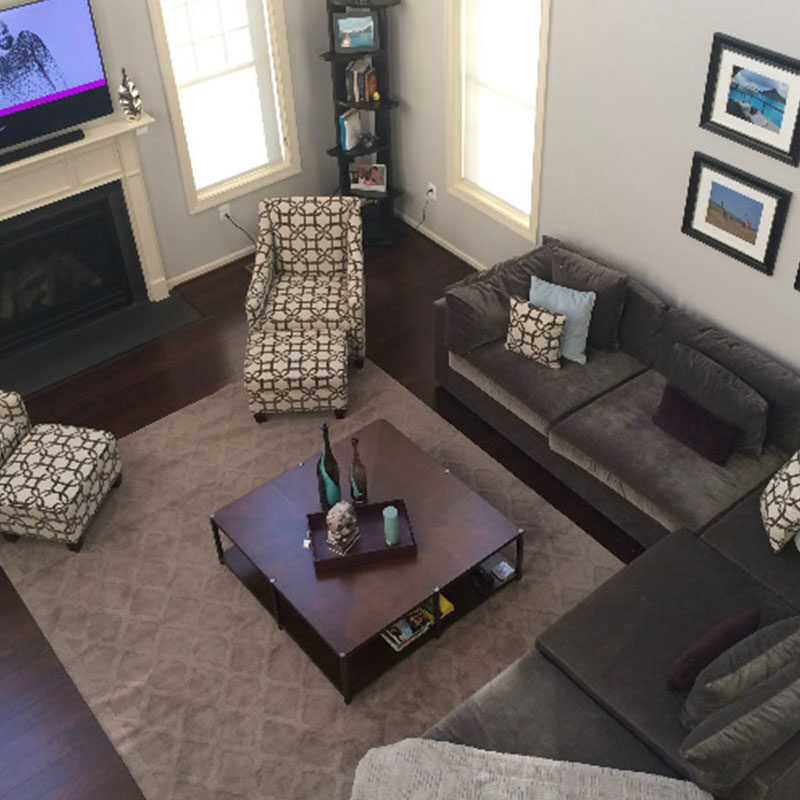 Cozy living room with dark sofas, patterned chairs, and a central coffee table.