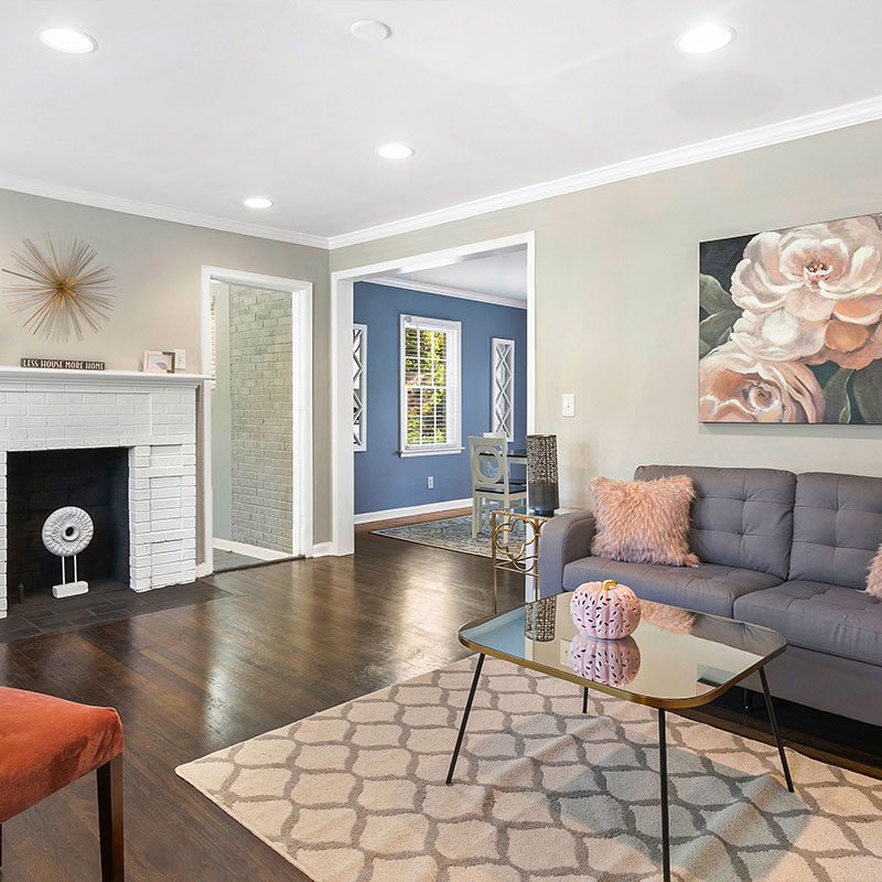 Modern living room with gray sofa and floral artwork.