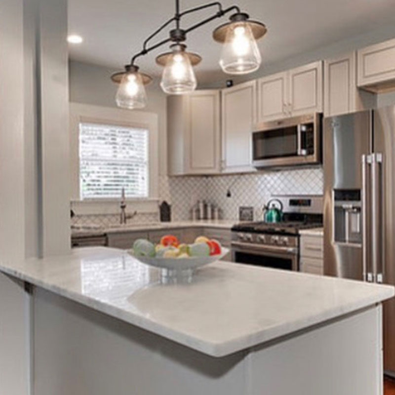 Modern kitchen with white cabinets, stainless steel appliances, and an island countertop.