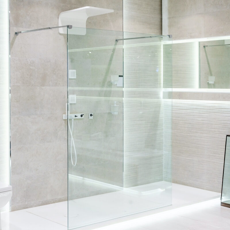 Modern walk-in shower with glass panels and built-in lighting.