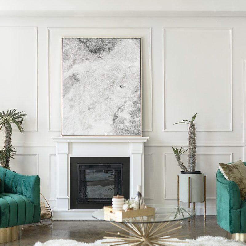 Elegant living room with green velvet sofas and a modern fireplace.