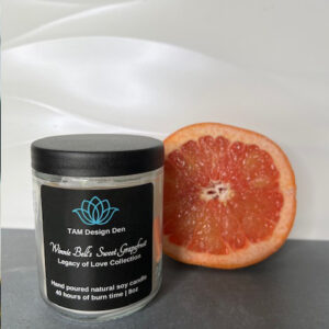 A jar of grapefruit body scrub with half a grapefruit beside it.