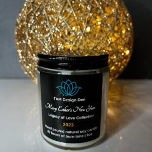 A black candle jar labeled 'The Vintage Door' with decorative golden lights behind.