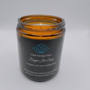 Amber glass jar candle with a black label and lotus design.