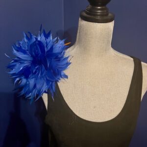 Blue feathered accessory on a mannequin's shoulder.