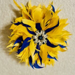 A vibrant yellow and blue feathered flower with a jeweled center.